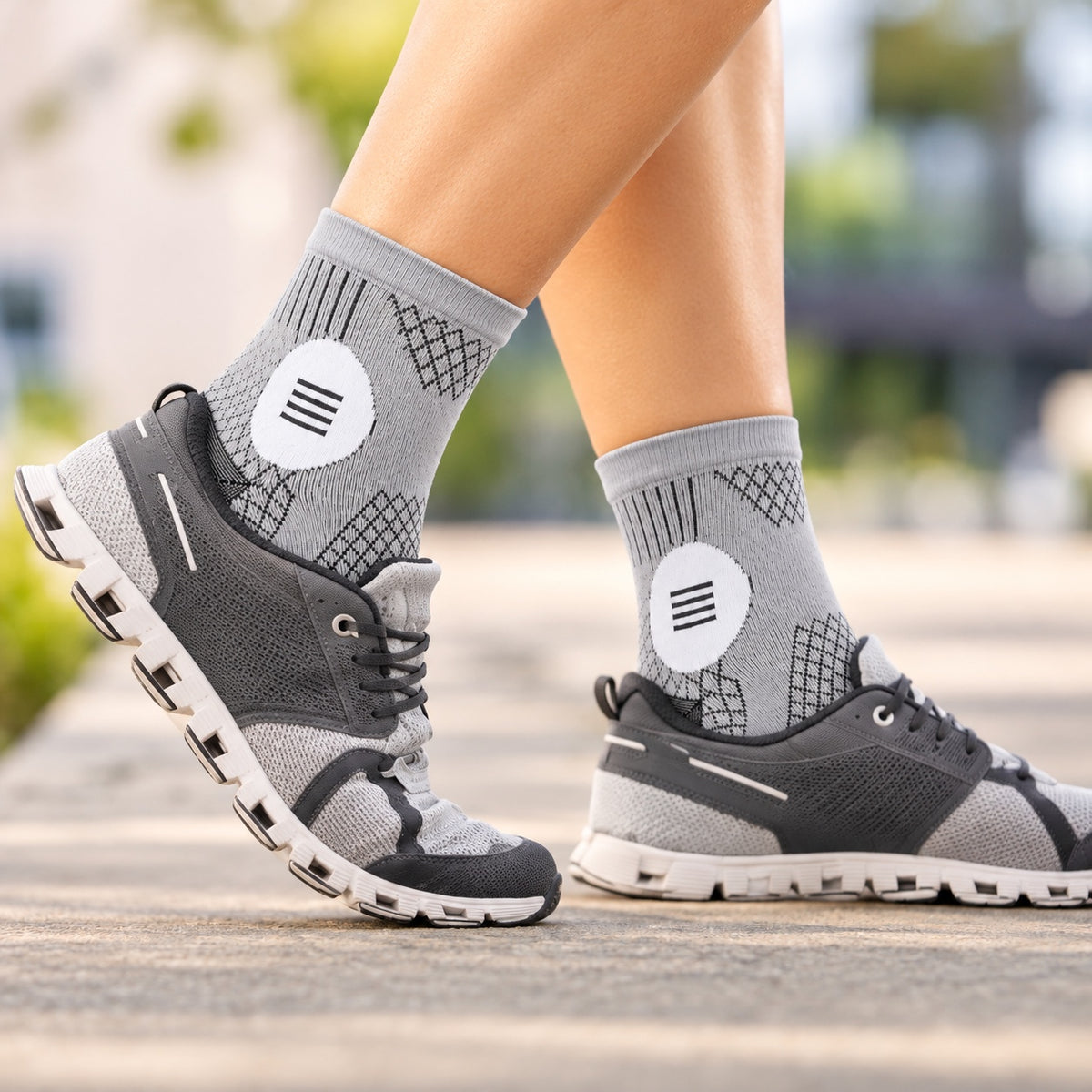 Grey and white ankle compression sleeves worn with grey running shoes